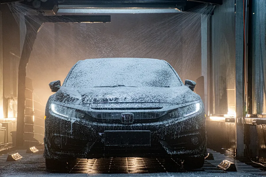 Ilustrasi mimpi mencuci mobil — a car is covered in snow in a garage