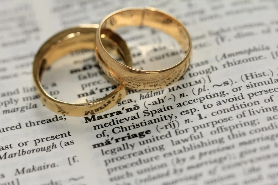 Ilustrasi mimpi menikah — two gold-colored rings on paper