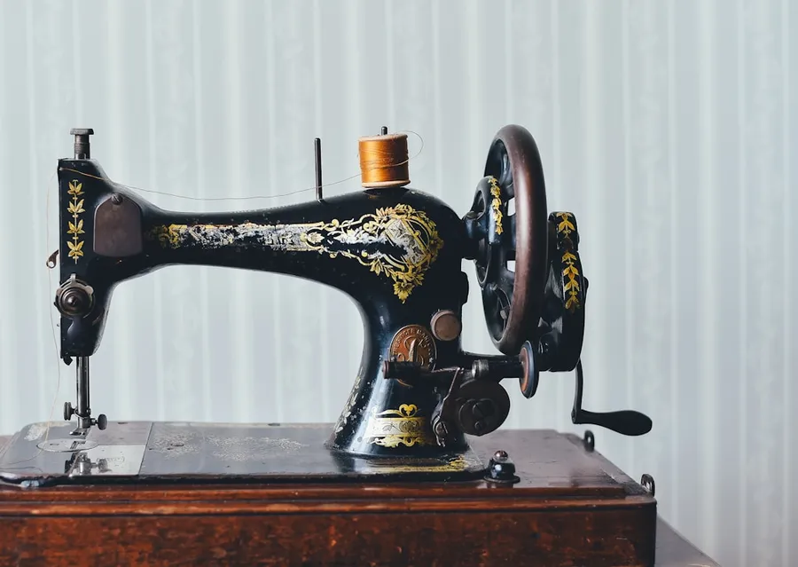 Ilustrasi mimpi menjahit — black and yellow metal sewing machine