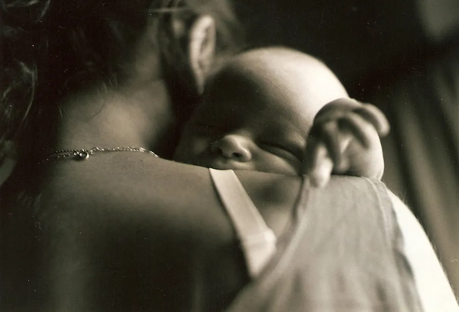 Ilustrasi mimpi menyusui bayi — a woman holding a baby in her arms