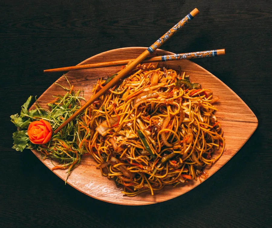 Ilustrasi mimpi mie goreng — pasta dish on brown ceramic plate