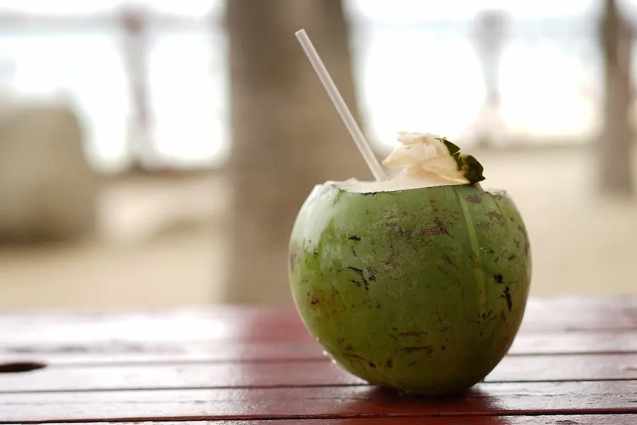 Ilustrasi mimpi minum kelapa — green fruit on brown wooden table