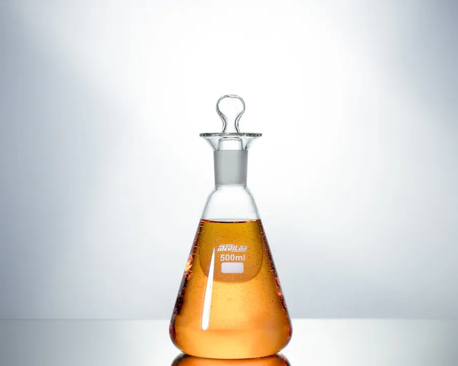 Ilustrasi mimpi minum racun — clear glass bottle with brown liquid