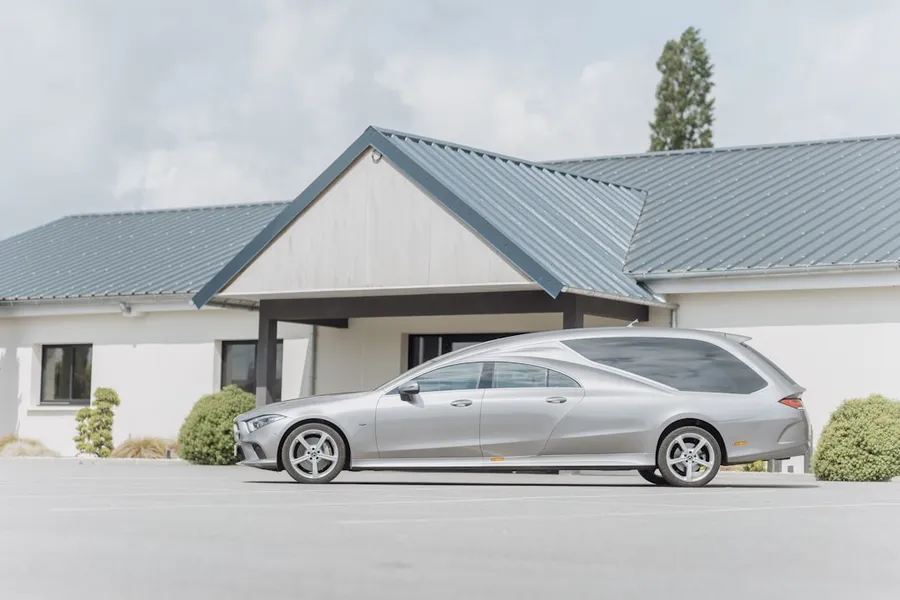 Ilustrasi mimpi mobil kematian — a silver car parked in front of a house