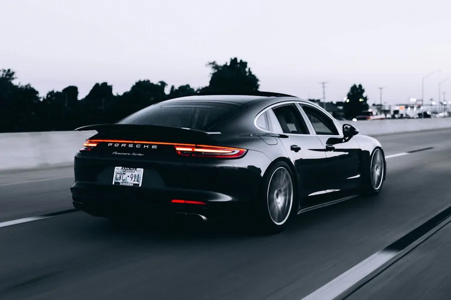 Ilustrasi mimpi mobil — running black Porsche sedan