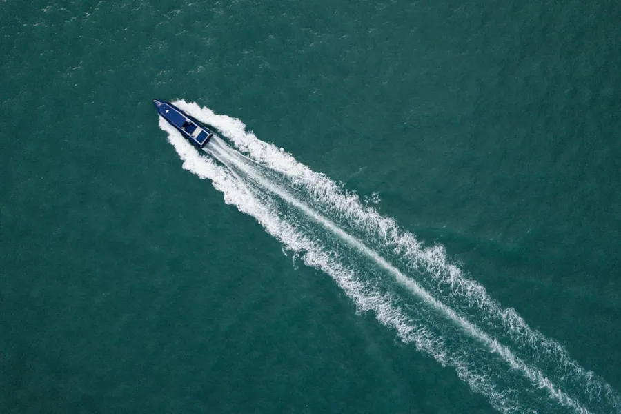 Ilustrasi mimpi motor boat — top view photography of blue boat at daytime
