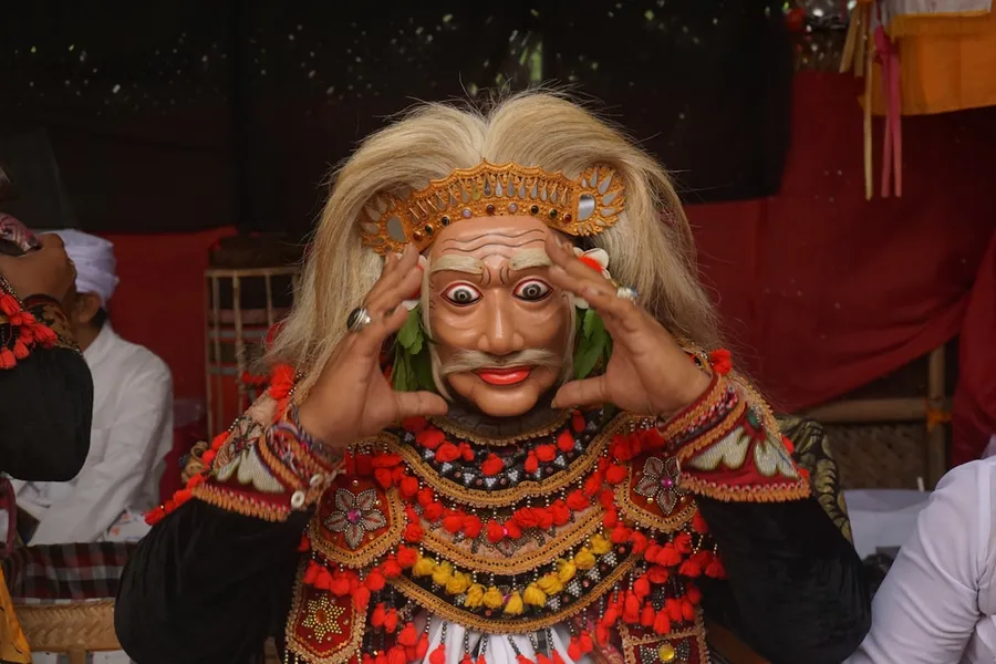 Ilustrasi mimpi naga tatmala — a woman in a costume holding her hands up to her face