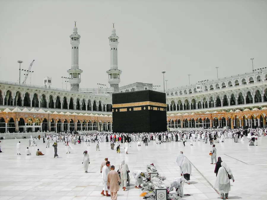 Ilustrasi mimpi naik haji — a group of people standing around a large building
