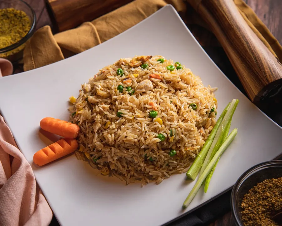 Ilustrasi mimpi nasi goreng — brown and green dish on white ceramic plate