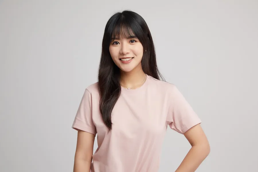 Ilustrasi mimpi orang asia — a woman in a pink shirt posing for a picture