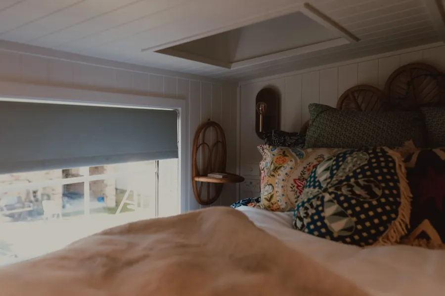 Ilustrasi mimpi orang buta — A cozy bedroom with a bed, window, and skylight.