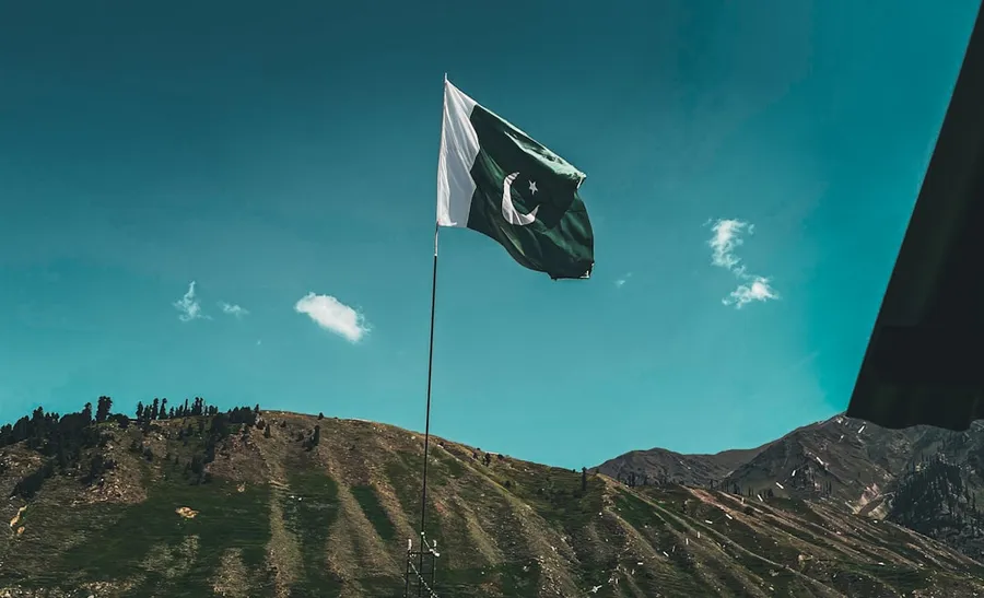 Ilustrasi mimpi orang pakistan — a flag flying on top of a mountain