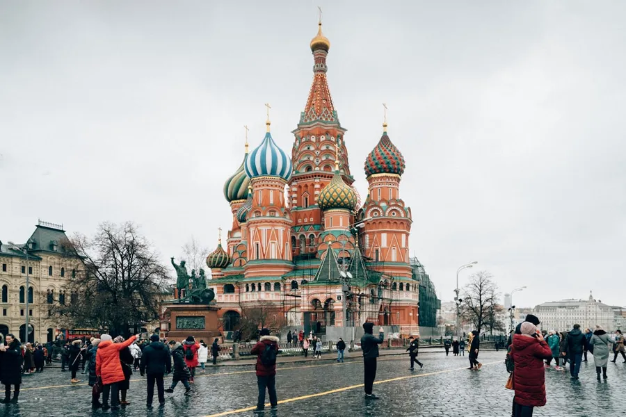Ilustrasi mimpi orang rusia — people walking on street near brown and green building during daytime