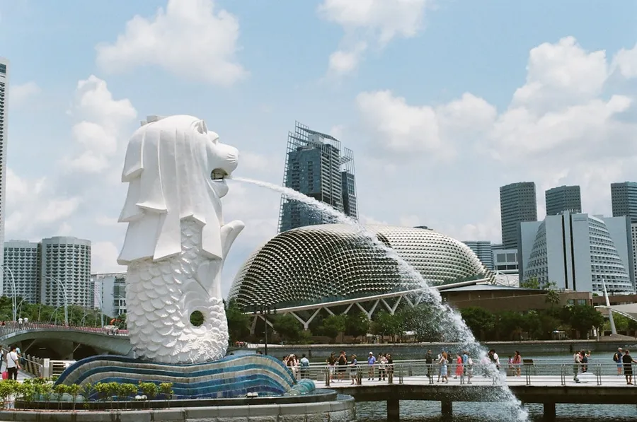 Ilustrasi mimpi orang singapura — white concrete statue near city buildings during daytime