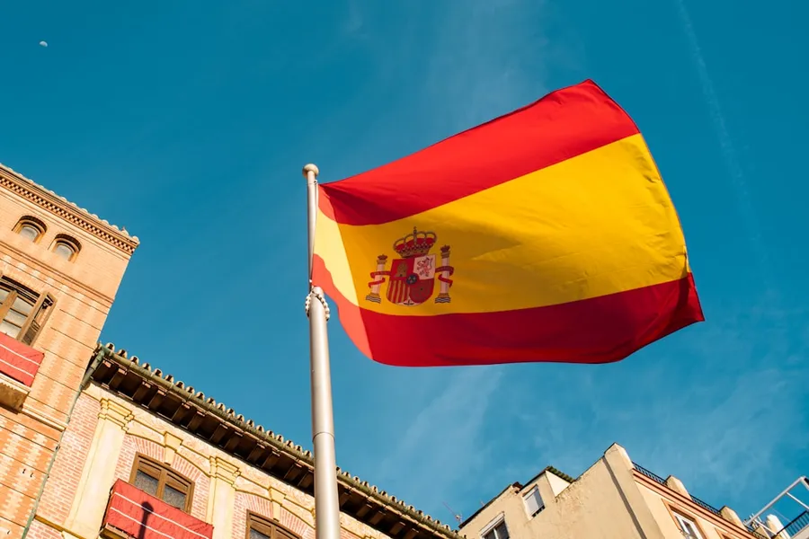 Ilustrasi mimpi orang spanyol — a spanish flag flying in front of a building