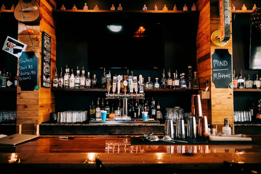 Ilustrasi mimpi pemabuk — a bar with many bottles of alcohol