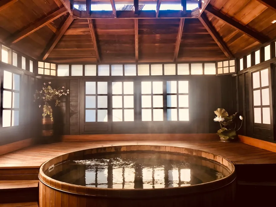Ilustrasi mimpi pemandian — brown wooden round table near glass window