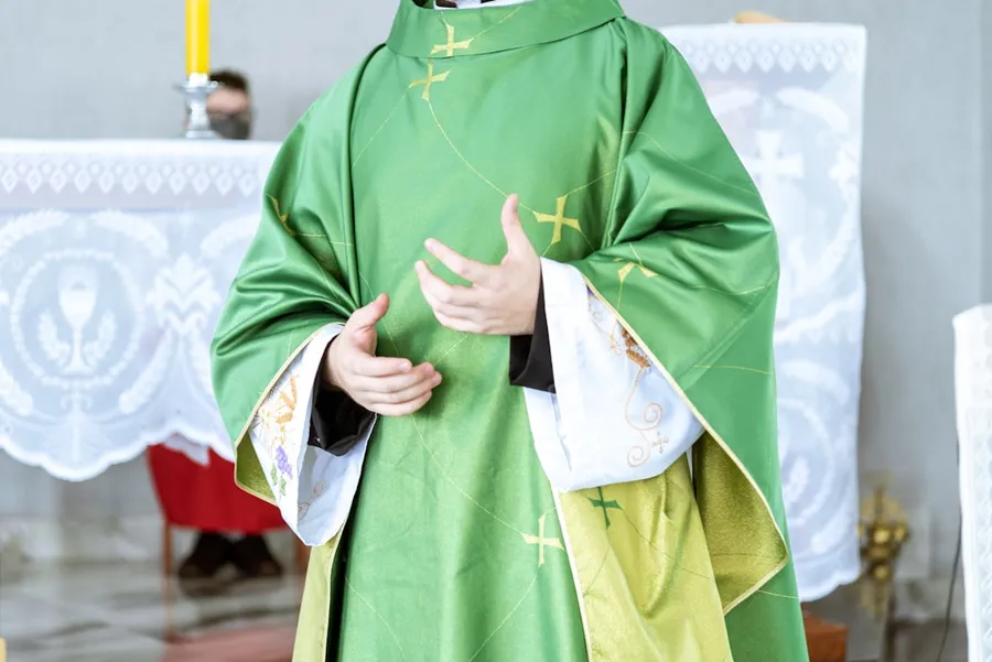 Ilustrasi mimpi pendeta wanita — a man in a priest's outfit standing in front of a cross