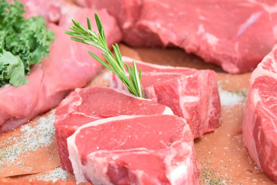 Ilustrasi mimpi penjual daging — raw meat with green leaves