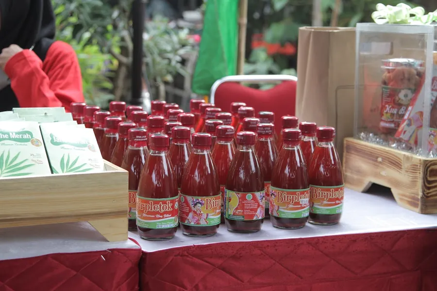 Ilustrasi mimpi penjual jamu — a table with many bottles of ketchup on it