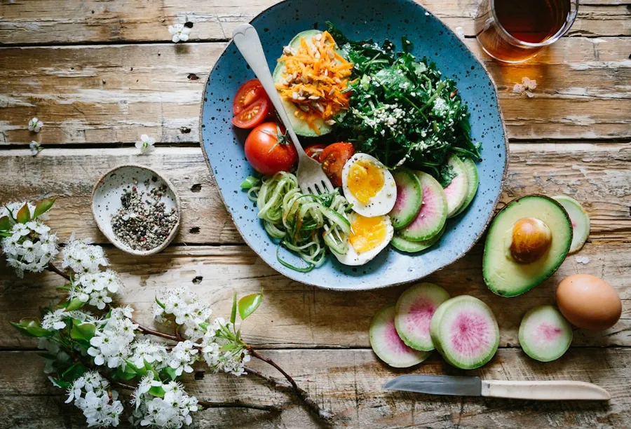 Ilustrasi mimpi periksa makan — poached egg with vegetables and tomatoes on blue plate