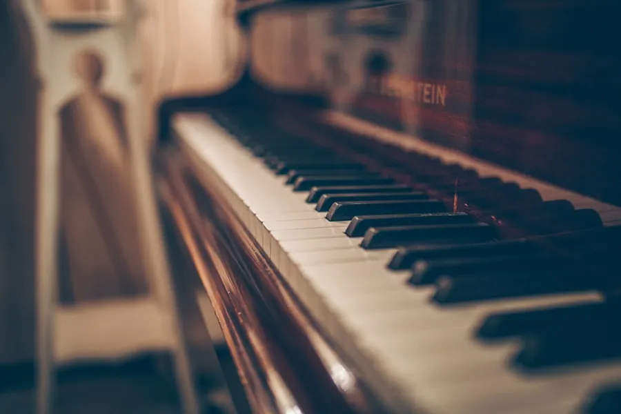 Ilustrasi mimpi piano — a close up of a piano with a person in the background