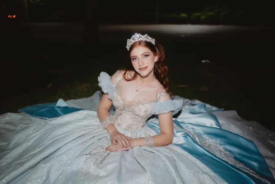 Ilustrasi mimpi putri raja — Young woman in a sparkling blue ball gown and tiara.