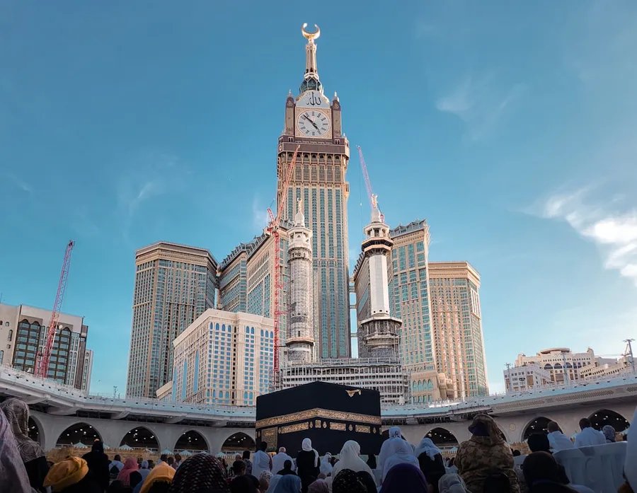 Ilustrasi mimpi qiblat — a group of people standing in front of a tall building