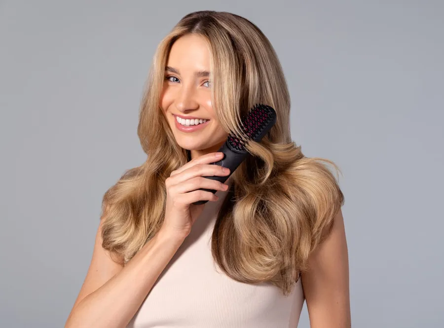 Ilustrasi mimpi rambut rontok — a woman holding a hair brush in her hand