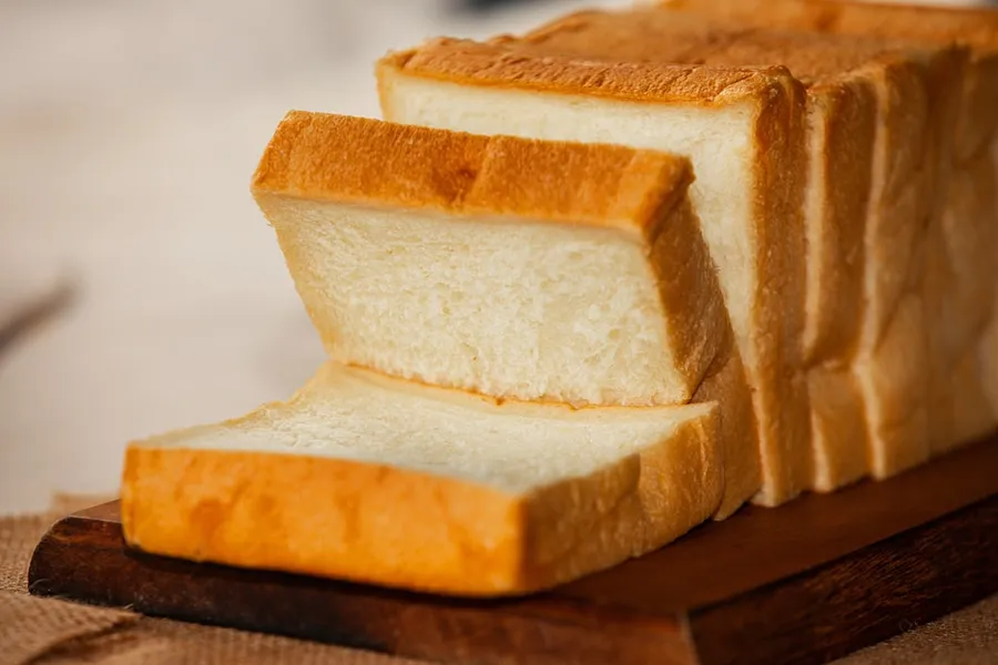 Ilustrasi mimpi roti tawar — brown bread on white ceramic plate