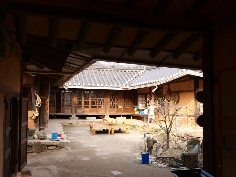Ilustrasi mimpi rumah adat — a view of a courtyard from inside a building