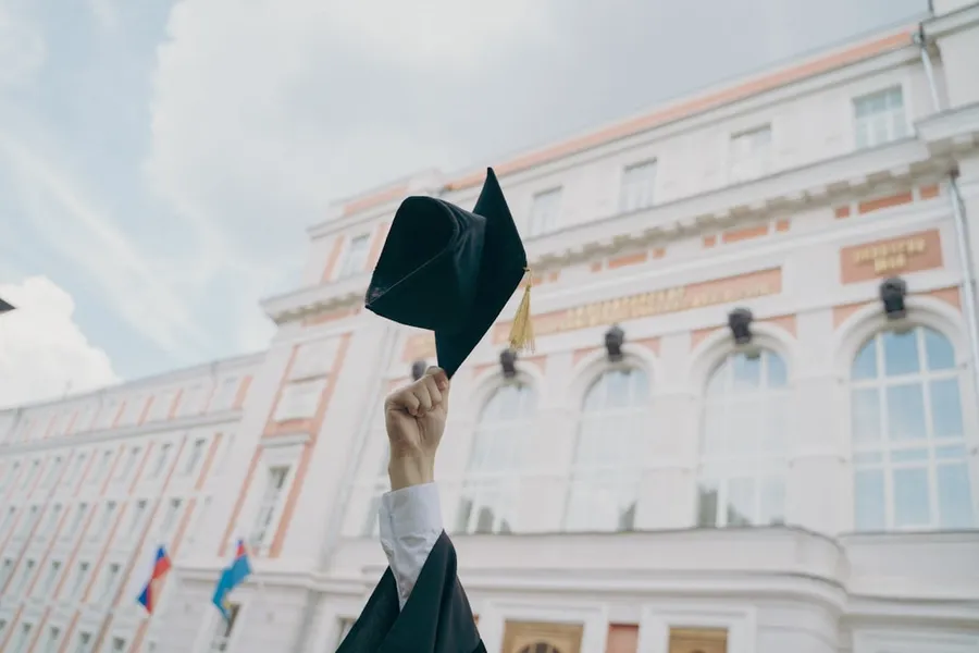 Ilustrasi mimpi sarjana — a person holding a black umbrella