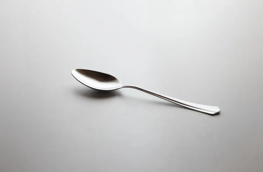 Ilustrasi mimpi sendok — silver spoon on white table