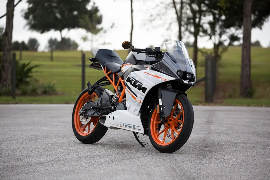 Ilustrasi mimpi sepeda motor — white and orange KTM sports bike selective focus photography