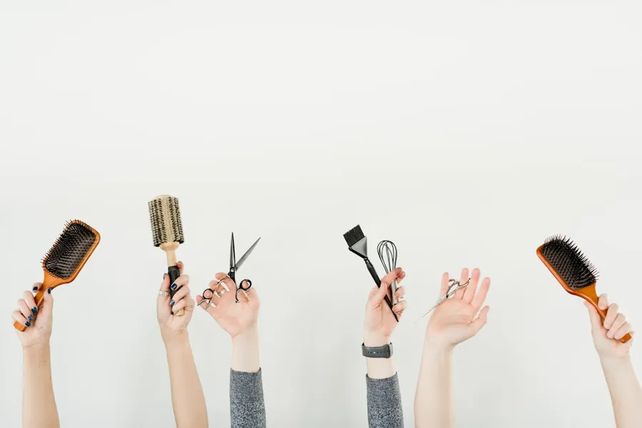 Ilustrasi mimpi sikat rambut — person holding silver and black hair brush