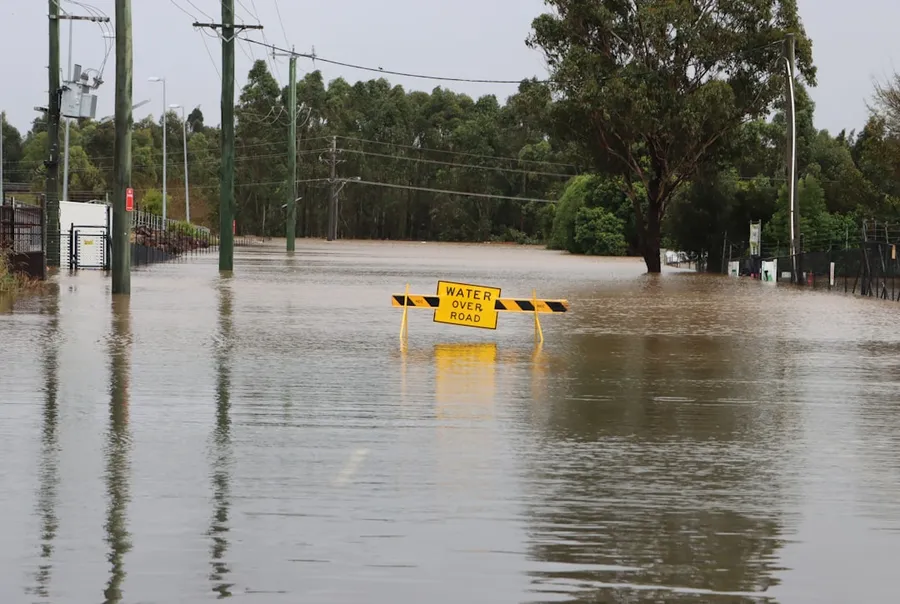 Ilustrasi mimpi sungai banjir — a flooded street with a yellow sign