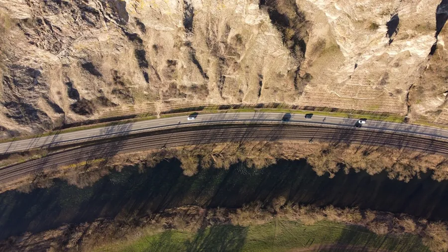 Ilustrasi mimpi tanah longsor — aerial view of road in between of rocky mountains during daytime