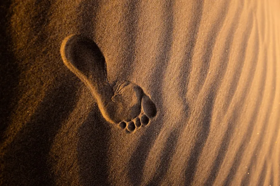 Ilustrasi mimpi tanda kaki — brown sand with heart shaped stones