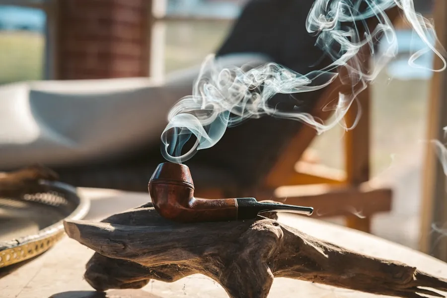 Ilustrasi mimpi pipa — smoke coming from brown smoking pipe