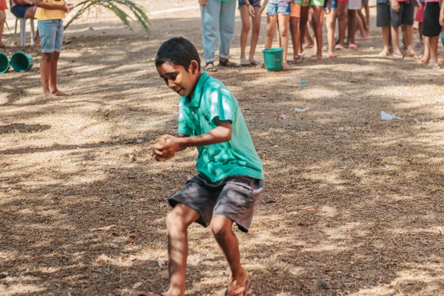 Ilustrasi mimpi teplekan — boy in green t-shirt and black shorts running on brown field during daytime
