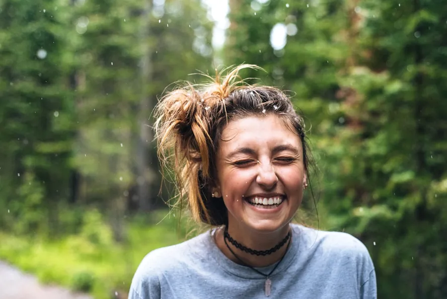 Ilustrasi mimpi tertawa — woman smiling near tree outdoor during daytime
