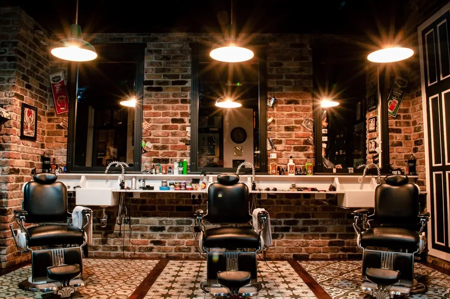 Ilustrasi mimpi tukang cukur — black leather barber chair near brown brick wall
