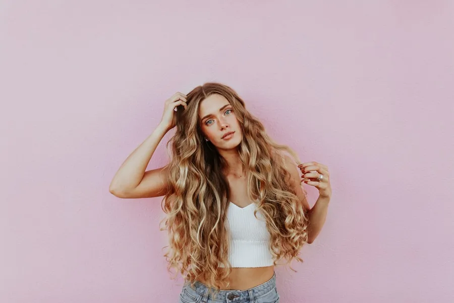 Ilustrasi mimpi wanita — woman standing next to pink wall while scratching her head